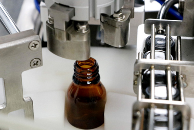 mesin pengisian botol minyak atas meja.jpg